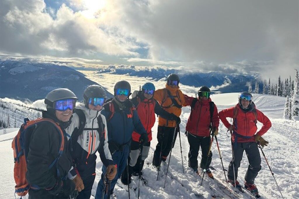 Extended family members stopped to take a picture after skiing on a mountain.